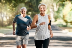 Image An older couple running through a park and the man is getting left in the dust.