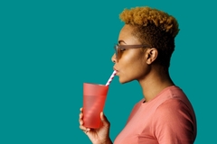 Black woman drinking with straw.