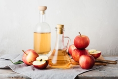 Image glass contains with apple cider vinegar next to apples