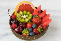 Image berries, cherries and orange slices in coconut shell bowl