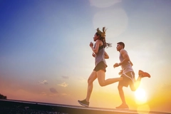 man and woman jog sunset