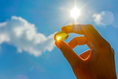 Image Holding yellow supplement in sunshine