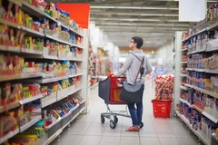 Image woman searching for product on supermarket shelf