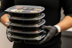 Image A person holding a stack of food containers