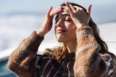 woman in snow applying sunscreen