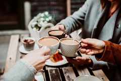 Image People drinking coffee around a table.