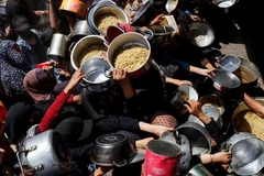 Image Palestinians gather to receive food aid.