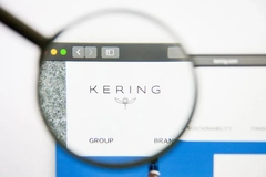 Image Kering logo under magnifying glass on computer screen.