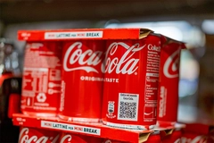 Image Coca-Cola soda cans on supermarket shelf.