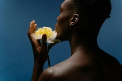 man holding flower against blue backdrop