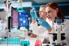 Image A scientist looking intensely at a test tube while in a lab.