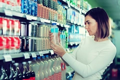 Image Consumer checking beverage label in supermarket.