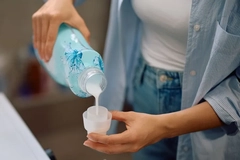 Image A person pouring cleaning liquid into a small cup