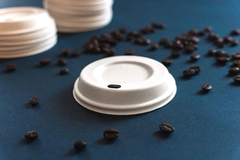 Image Dry Molded Fiber coffee lid and coffee beans.