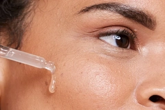 Image A girl putting a serum on her cheek.