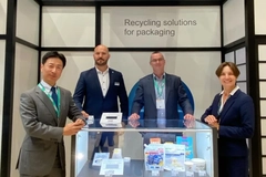 Image A group of men standing in front of a glass display case