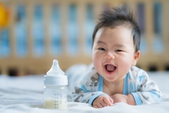 Image Happy Asian baby drinking milk