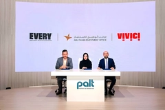 two men and a woman sitting behind a desk on stage
