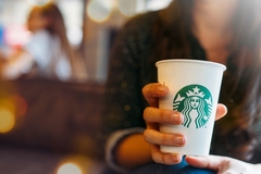 Image Woman holding a cup of Starbucks coffee.