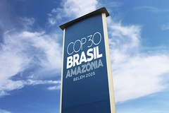 COP30 Brazil flag against blue sky.