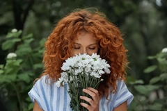 Image woman with red hair smelling flowers