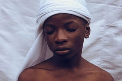 Image boy with headscarf standing against backdrop