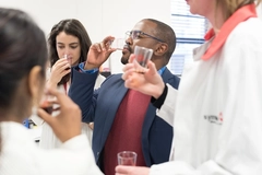Image scientists tasting liquid flavors in transparent cups