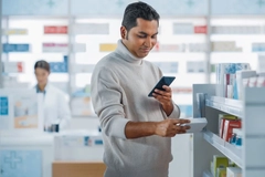Image Man checking supplement box in store