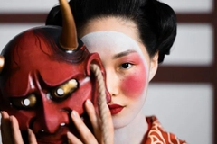 woman in traditional chinese attire holding a traditional face mask