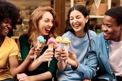 Image four young multi ethnic friends eating colorful ice creams