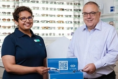 Image two people presenting contact lens recycling box