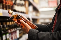 Image A person holding a bottle of Whisky