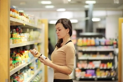 A woman examines supplement labels in a store.