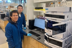 Image A couple of men standing in a lab.