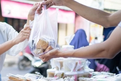 Image A person handing a bag of food to another person