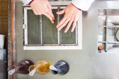 Image A person's hands on a material