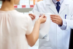 A person receives a bag from a person in a white coat