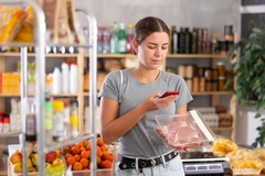 Woman shopping for meat in the grocery store.