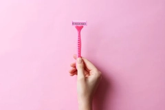 Image woman holding pink razor