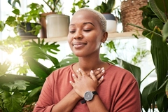 Image young woman by plants looking peaceful with eyes closed