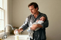 Image father preparing baby bottle while soothing crying infant in kitchen