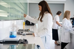 Image female scientist in lab with yellow liquid in test tube