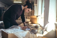 Image man looking over e commerce packaging parcels