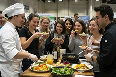 Image Trade show visitors try food flavors.