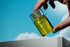 A hand holding Olaplex bonding oil.