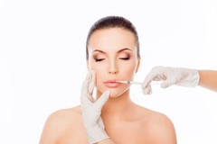 Image A woman getting an injection into her lip.