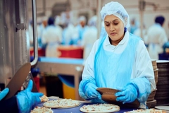 Image Greencore worker making pizza.