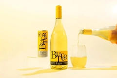 Image A can next to a bottle of white wine being poured into a glass