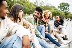 Image Happy group of trendy young people laughing sitting in city street.