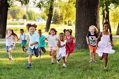 Image A group of happy children of boys and girls run in the Park